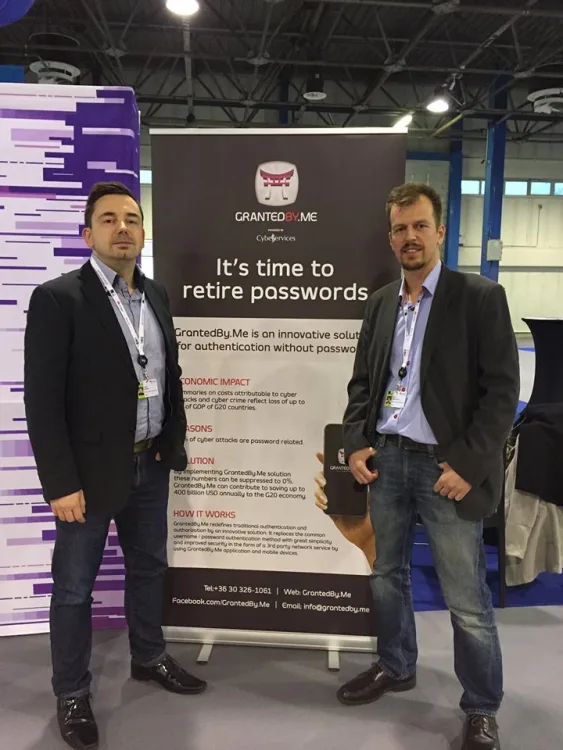 2 men posing next to a board