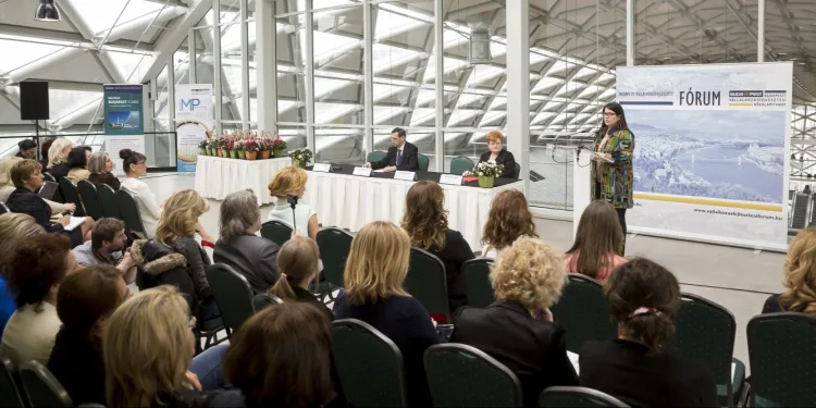 a woman is giving a speech to an audience