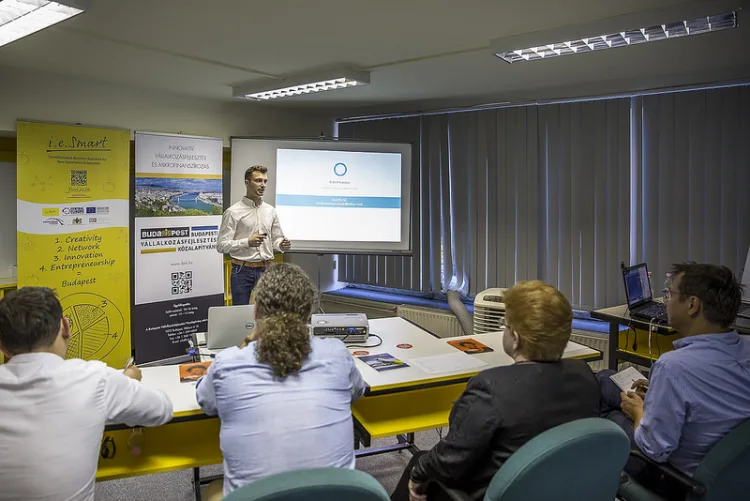 a man is delivering a lecture to a group of people