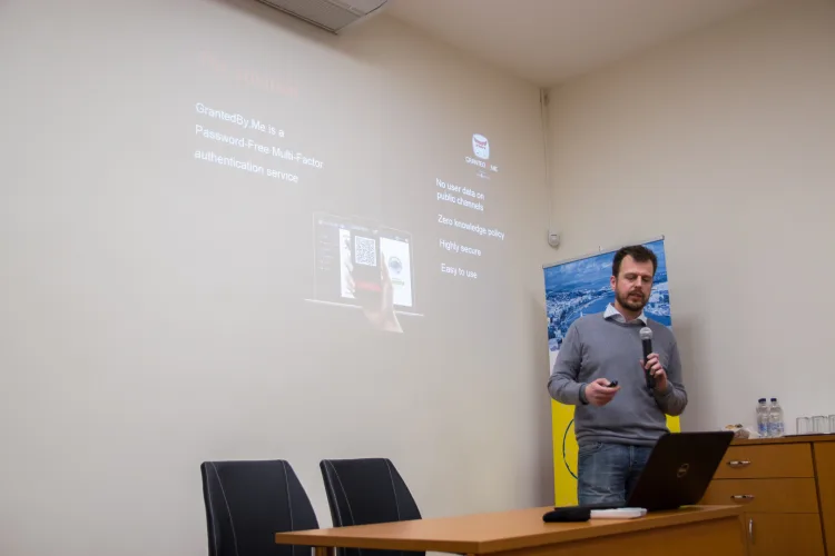 a man is holding a microphone and talking about his presentation