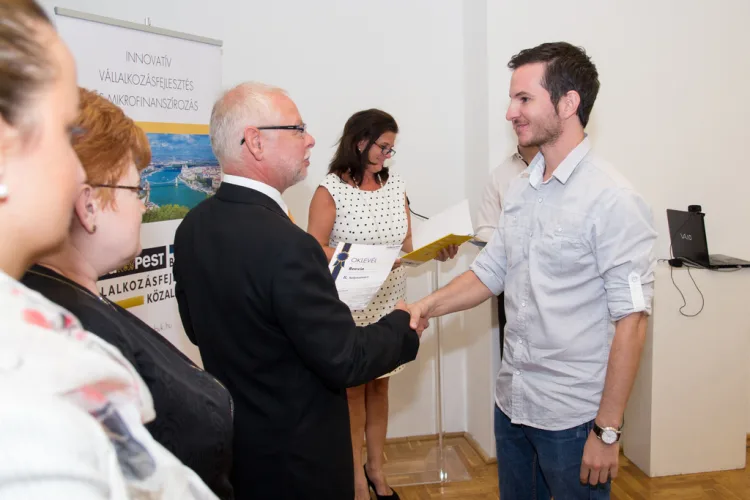 a middle aged man shakes the hand of a young man