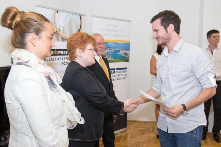 a middle aged woman and a young man are shaking hands