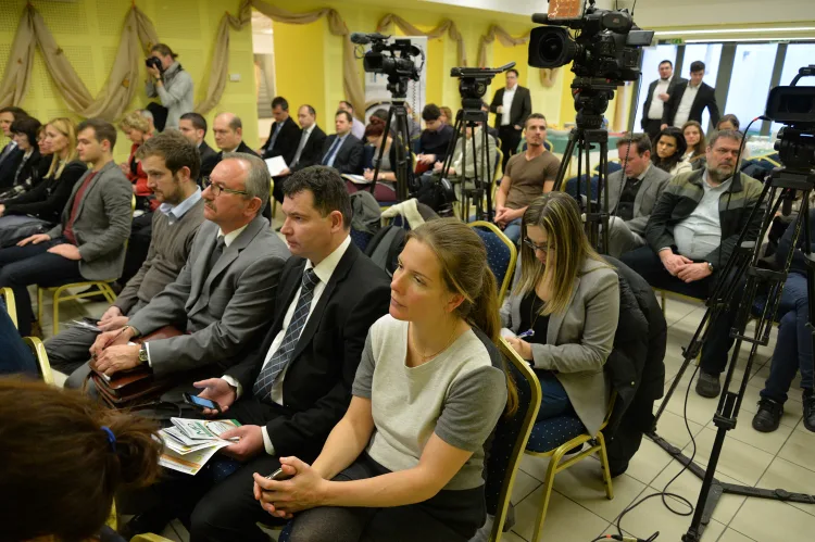 an audience is taking notes and listening to a lecture