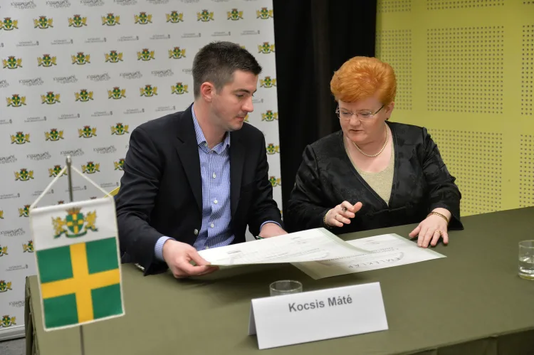 a man and a woman take a look at the certificates they signed